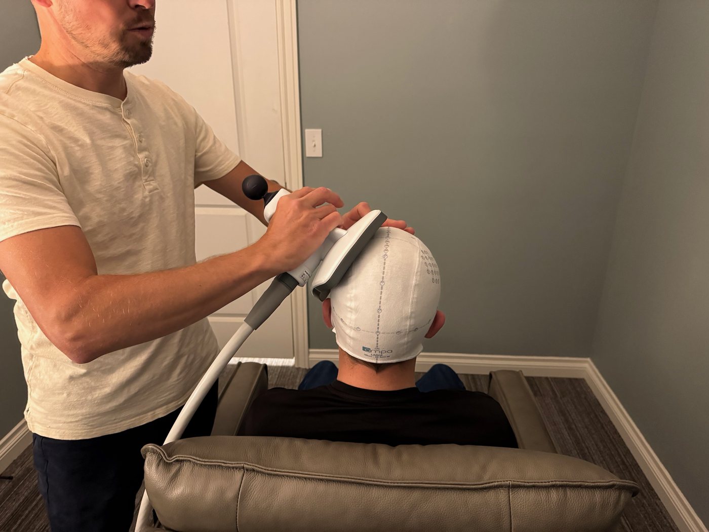 A clinician positions the coil for a seated patient