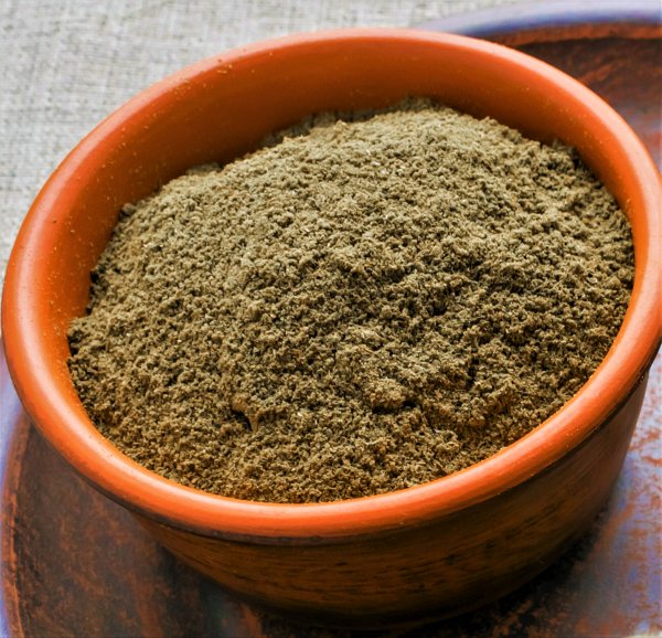 Ground triphala in a clay bowl